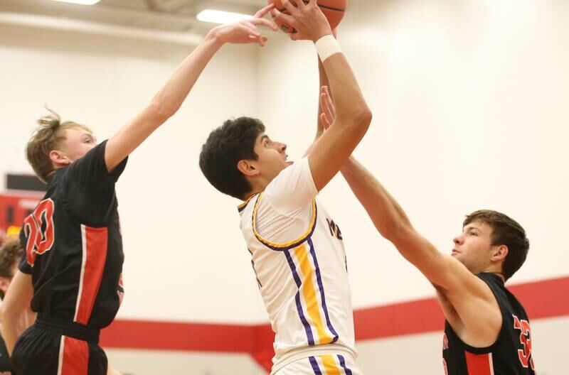 Mendota's Izaiah Nenez splits Stillman Valley defenders Ian Seper and teamate Jacob Rhodes to score a basket during the 49th annual Colmone Classic Tournament on Wednesday, Dec. 6, 2023 at Hall High School.