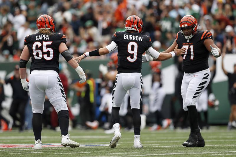 Cincinnati Bengals offensive tackle La'el Collins (71) celebrates with Cincinnati Bengals quarterback Joe Burrow (9) after a play during an NFL football game against the New York Jets, Sunday, Sept. 25, 2022, in East Rutherford, N.J. The Cincinnati Bengals won 27-12. (AP Photo/Steve Luciano)