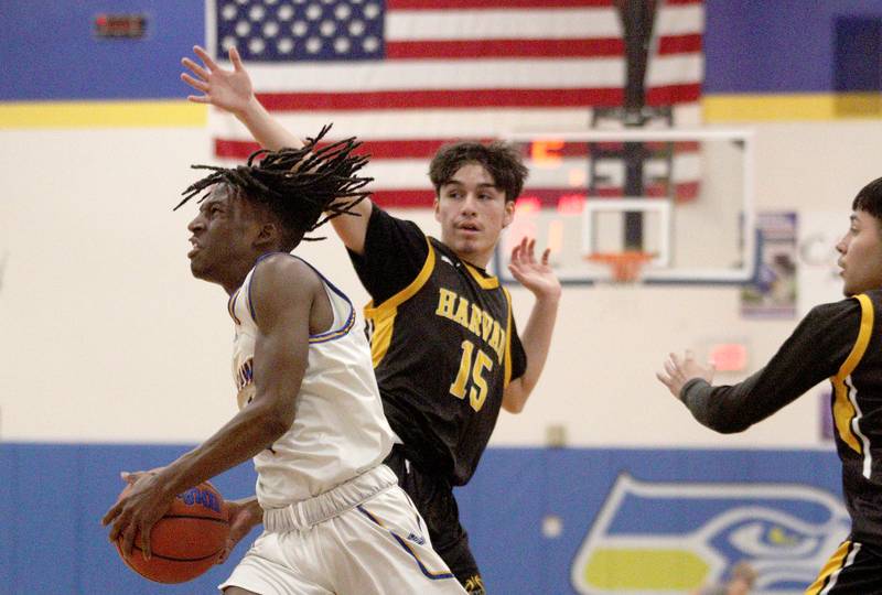 Johnsburg’s Jarrel Albea moves the ball past Harvard’s Martin Quintero in varsity boys basketball at Johnsburg Saturday.