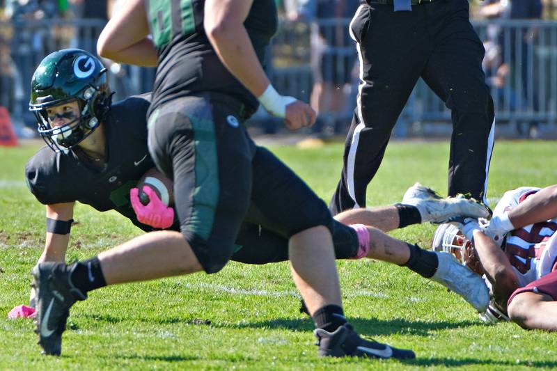 Glenbard West's Joey Pope (left) lunges from the grasp of Lockport's Kyle Collins during an IHSA Class 8A playoff game on Oct. 29, 2022 at Glenbard West High School in Glen Ellyn.