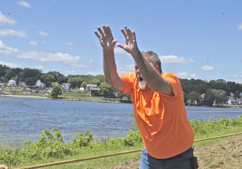 Tug  master Tim Allen yells commands to his team from Peacocks Tavern at the Port Byron-hosted Great River Tug Fest across the Mississippi on Saturday, Aug. 10, 2024.