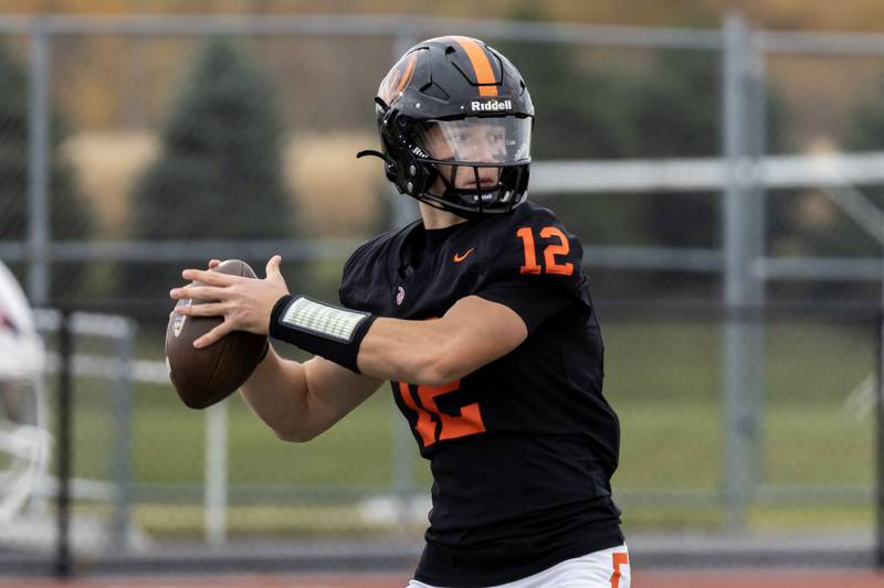 Lincoln-Way West's Grant Tustin looks for an open teammate during a 7A varsity football playoff game against Kenwood at Lincoln-Way West on Nov. 8, 2025.