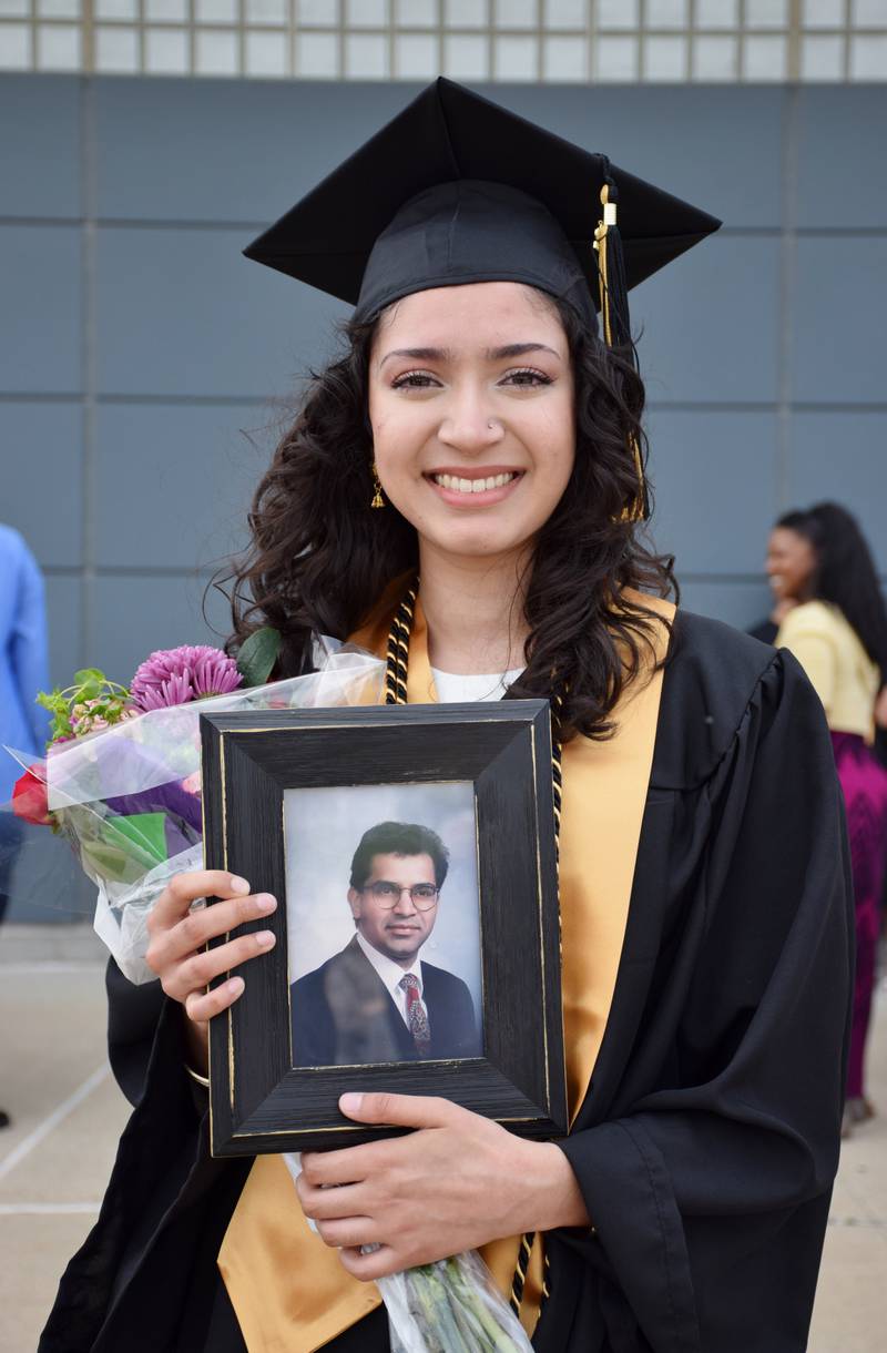 Sarah Siddiqui has her photo taken with a framed photograph of her deceased father, Zahir Siddiqui, after the commencement ceremony for Sycamore High School's Class of 2022, held Sunday, May 22, 2022 at Northern Illinois University's Convocation Center in DeKalb.