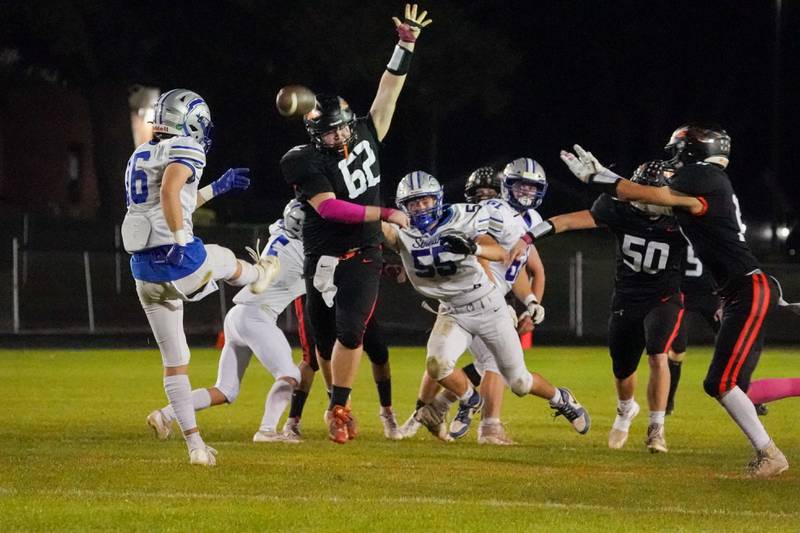 Sandwich’s Tate Frieders (62) attempts to block a punt by Woodstock's Charlie Walrod (16) during a football game at Sandwich High School on Friday, Oct. 11, 2024.