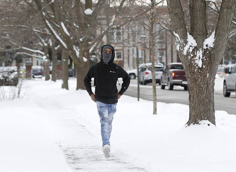 Crystal Lake Central High School student Darron Jackson walks home from school Monday, Jan. 24, 2022, along after Caroline Street after a McHenry County received a fresh snowfall.