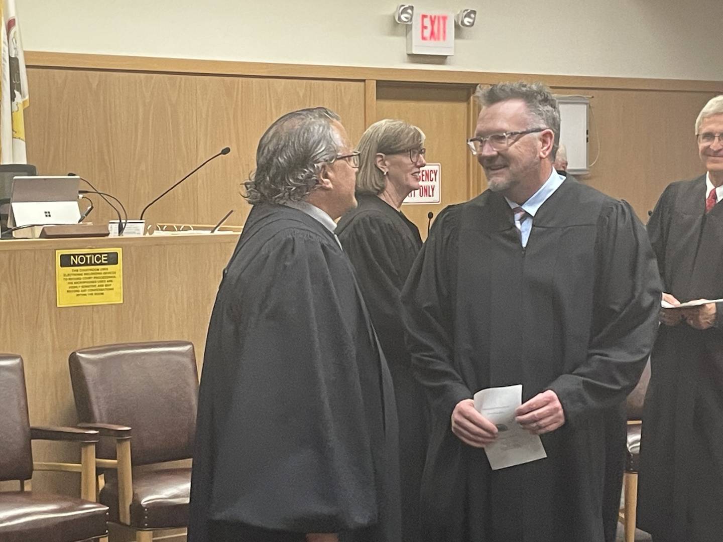New Judge Greg Sticka (left) is congratulated by Judge Mark Anderson following Sticka's swearin-in Friday, May 15, 2026. At center and right are Judge Karen C. Eiten and retired Judge Michael C. Jansz.