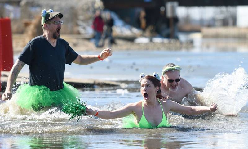 Sara Lorenzo of Lindenhurst reacts after jumping in the 34-degree water of Nippersink Lake on Sunday during the Fox Lake Polar Plunge for Special Olympics. Plunging with her were Rob Zando of Spring Grove, left, and Rob Blaire of Crystal Lake.