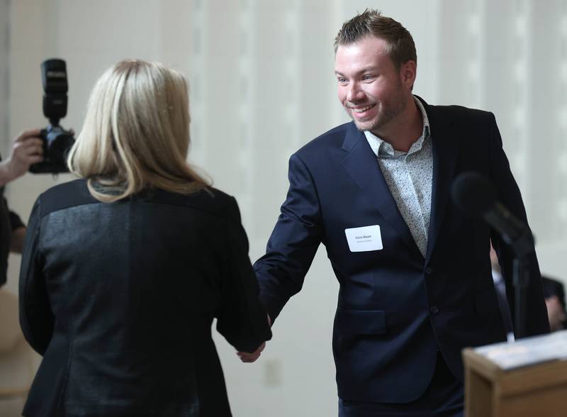 Chris Mayer, (right) founder and owner of Windows Distillery, is introduced as the winner of the Community Diamond Award Thursday, March 5, 2026, during the Sycamore Chamber of Commerce Annual Meeting in Memorial Hall at St. Mary's Catholic Church in Sycamore.