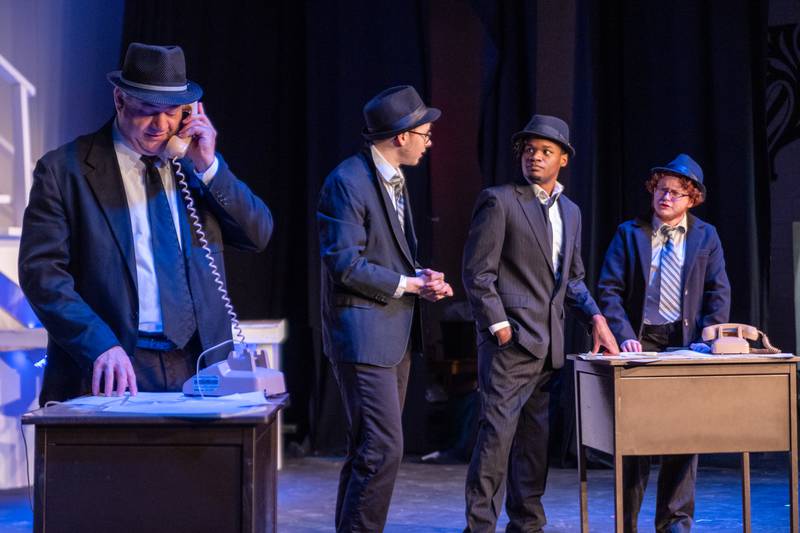 (left) Jeff Sudakov (Played by Carl Hanratty) answers phone, whist (left to right) Dollar (Played by Cole Roark), Branton (Played by Jeremiah Noar) and Cod (Played by Forrest Boes) argue in background on Monday, March 24, 2025 at River Valley Players Theatre in Henry.