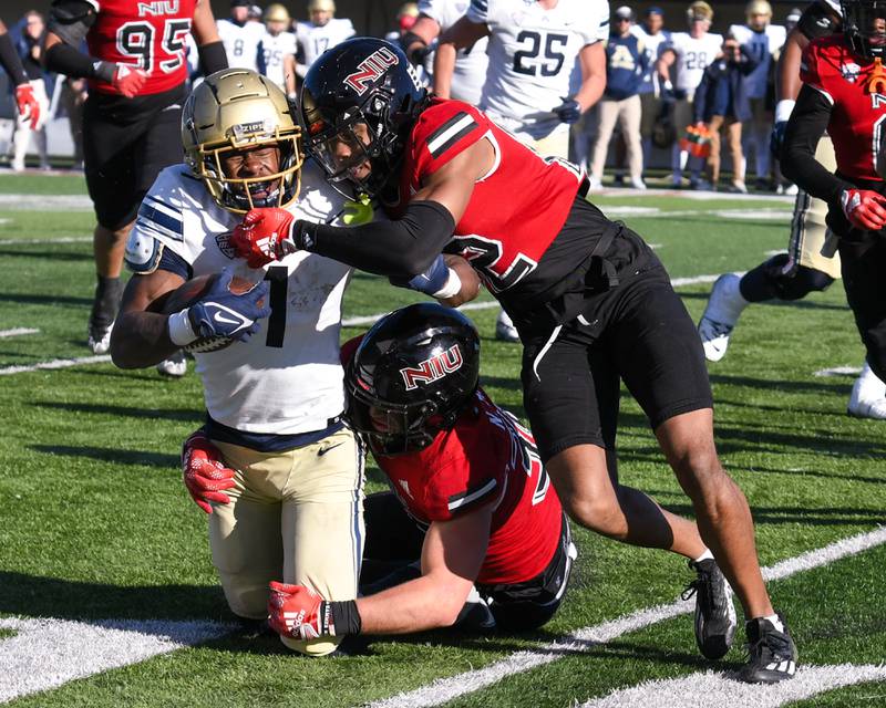 NIU linebacker Nick Rrattin, center, and teammate Eric Rogers bring down bring down Akron’s ball carrier in the second quarter Nov. 26th at Huskies stadium in DeKalb.