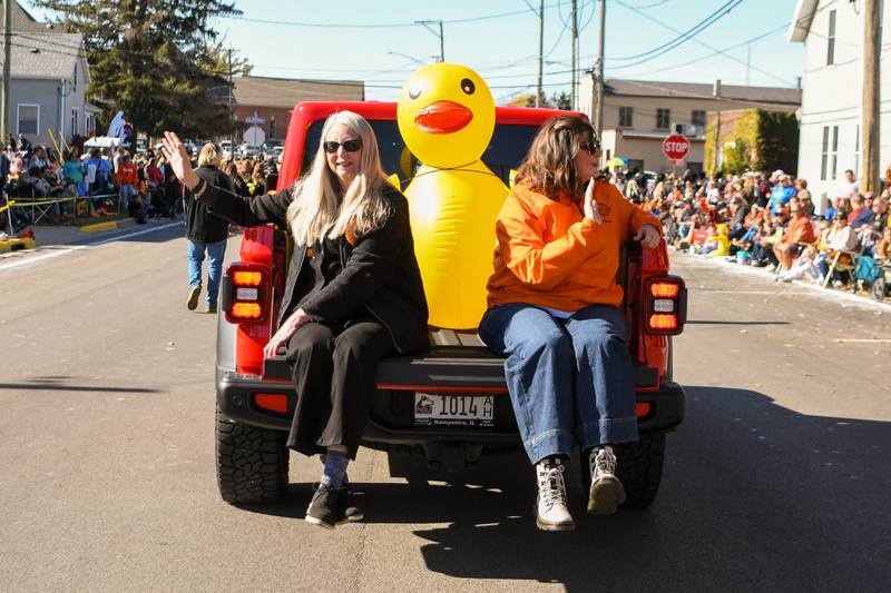 The family of the late Jim Dombek wave from the Pumpkin Parade's Grand Marshall float during the 63rd annual Sycamore Pumpkin Festival on Sunday, Oct. 27, 2024, downtown. Dombek was a longtime president of the Sycamore District 427 school board and an active volunteer with festival organizers.