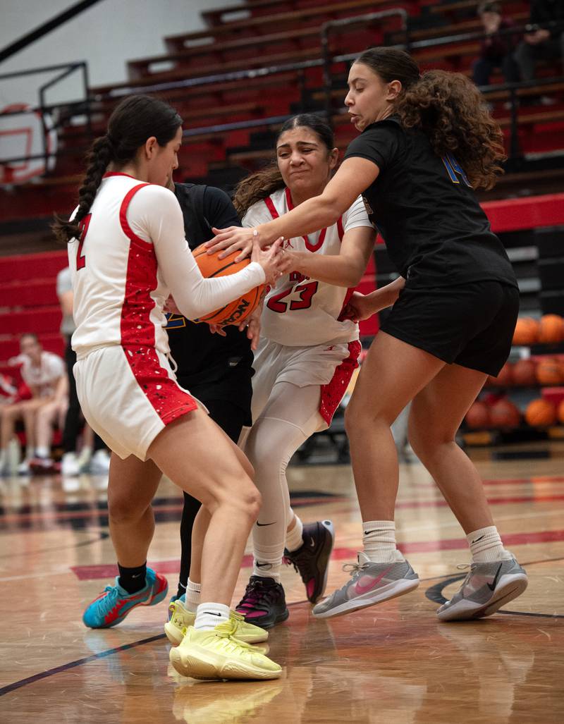 Bradley-Bourbonnais's Semma Mohammad, center, passes off to Abby Bonilla, left, as she is pressured by Sandburg's Gabriella Aldrete, right, and Makaleigh Terry, background left,    in a game on Saturday, January 3, 2026.