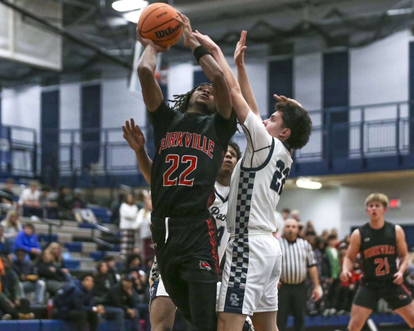 Yorkville's Braydon Porter (22) is defended on a shot by Oswego East's Noah Yu (22) during their basketball game between Yorkville at Oswego East. Friday, Dec 19, 2025 in Oswego.