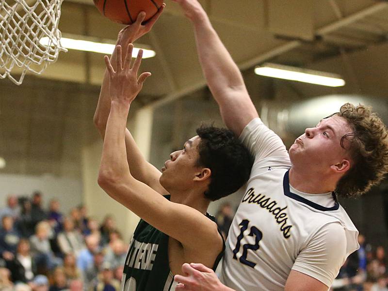 St. Bede's Isiah Hart lunges to the basket over Marquette's Krew Bond in the Class 1A Regional semifinal on Wednesday, Feb. 22, 2023 at Midland High School.