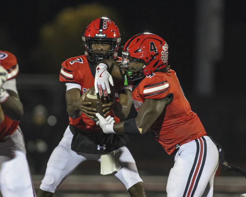 Bolingbrook's Timmie Lewis II (4) takes the handoff from Tyson Ward (7) during football game between Yorkville at Bolingbrook Friday, Oct 24, 2025 in Bolingbrook.