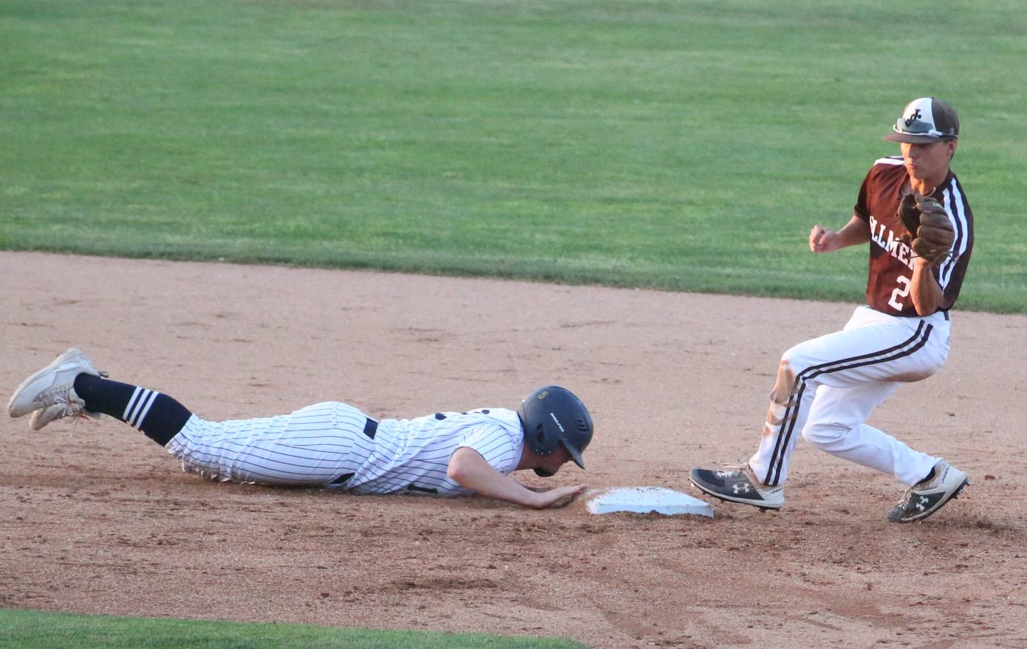 Joliet Catholic's Tommy Kemp squeezes his glove as Quincy Notre Dame's Nolan Robb slides back into second base during the Class 2A state semifinals Friday, June 2, 2023, at Dozer Park in Peoria.