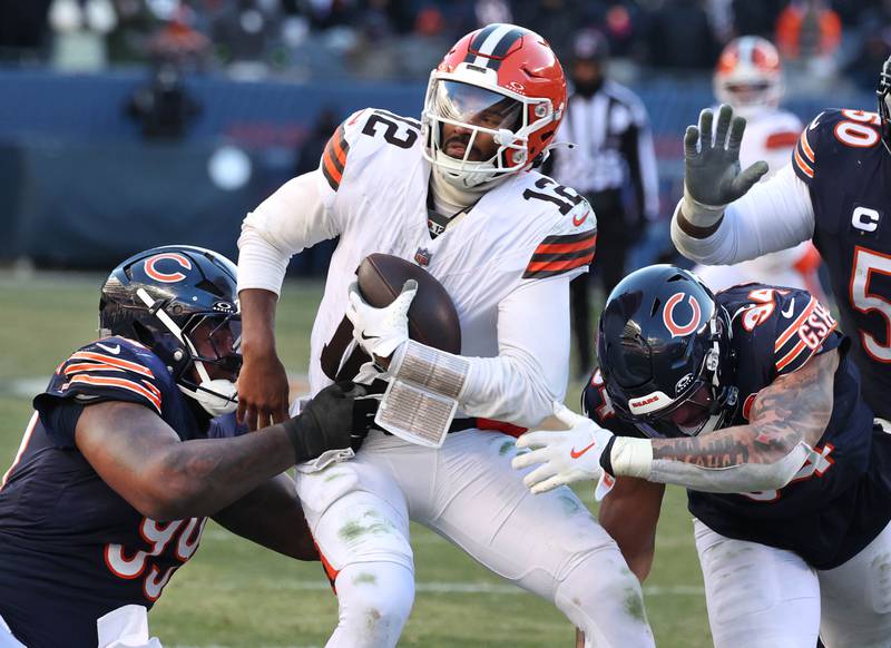 Chicago Bears defensive tackle Gervon Dexter Sr. (left) and defensive end Austin Booker sack Cleveland Browns quarterback Shedeur Sanders during their game Sunday, Dec. 14, 2025, at Soldier Field in Chicago.