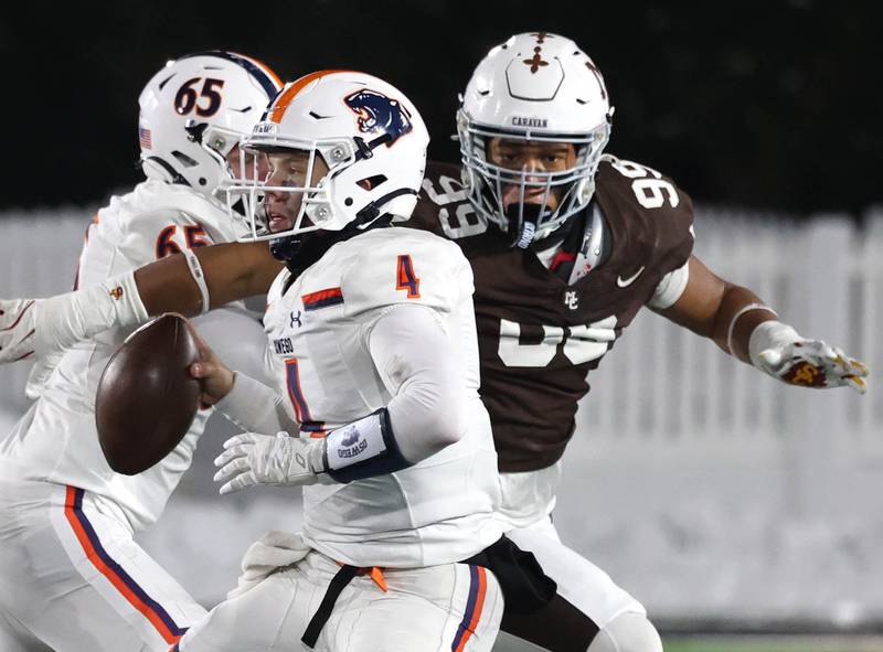 Oswego's Drew Kleinhans looks for a receiver as he is pressured by Mount Carmel's Braeden Jones Wednesday, Dec. 3, 2025, during their IHSA Class 8A state chamionship game in Huskie Stadium at Northern Illinois University in DeKalb.