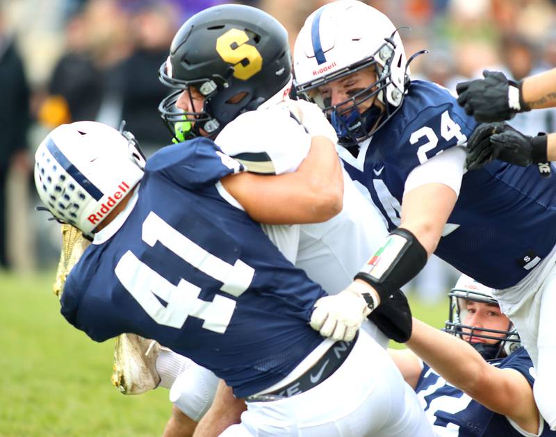 Cary-Grove’s Henry Kaiser, right, and Nate Jonas, left, bring down Sycamore’s Griffin Larsen  in IHSA football Class 5A first-round playoff action at Al Bohrer Field on the campus of Cary-Grove High School in Cary on Saturday, November 1, 2025.