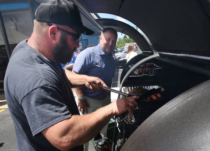 Dave Zerfas and Shawn Hardan help cook hamburgers, brats and hot dogs to benefit Princeton youth baseball and softball leagues on Wednesday, May 29, 2024 at Princeton Chevrolet GMC. All food and drinks were donated by Princeton Chevrolet GMC for the fundraiser.