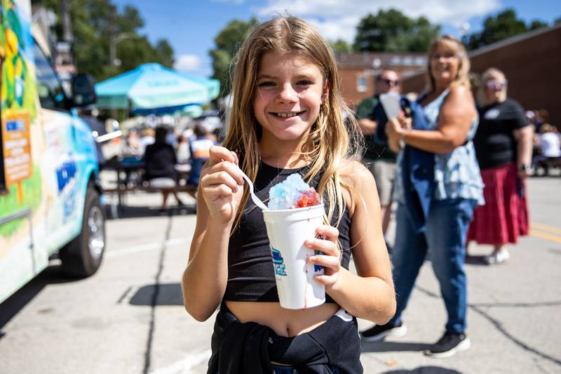 Ten-year-old Layla Giertych enjoys an icy treat during Fire Fest, held in Lockport's Historic District, on August 10, 2024.