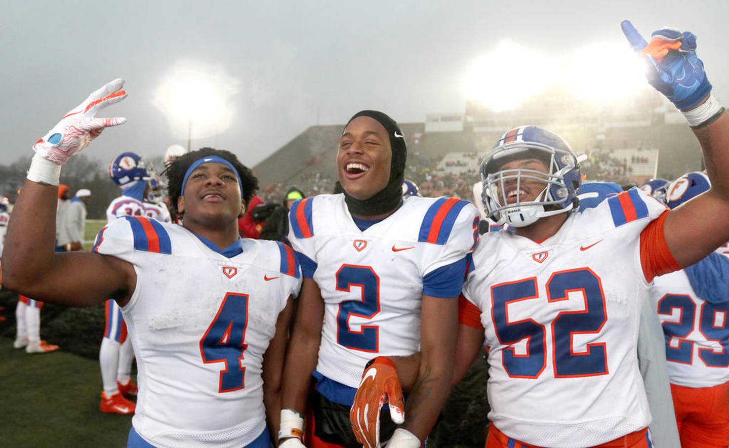 East St. Louis players DeMonta Witherspoon, (left) Antonio Johnson and Darran Perkins (right) celebrate after their Class 6A state football championship win over Prairie Ridge Saturday in Huskie Stadium at Northern Illinois University.