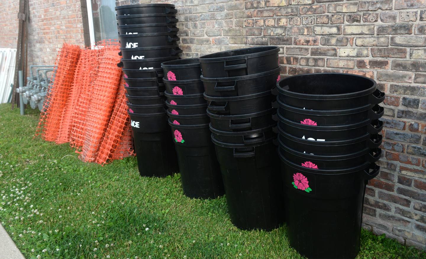 Waste barrels and fencing are lined up along a building near the Riverfront on Thursday in Dixon waiting to be deployed for the Petunia Festival.