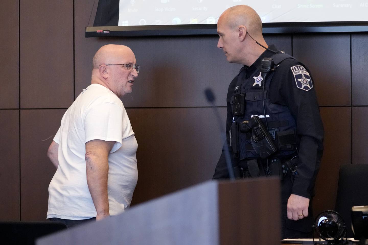 Robert E. Crimo Jr., left, listens to a Lake County Courthouse Sheriff at the Lake County Courthouse, Wednesday, Nov. 15, 2023, in Waukegan, Ill. Crimo Jr., the father of the suspect in a deadly Fourth of July parade shooting in suburban Chicago turned himself in Wednesday to begin a 60-day jail sentence, after pleading guilty to charges arising from his sponsorship of his son's application for a gun license.