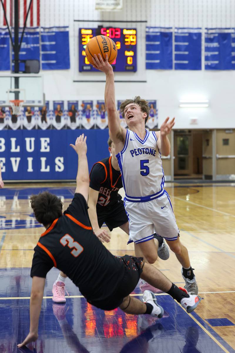 Peotone's Nate Wehrmann goes for the shot as Beecher's Kyle Kasput looks to draw a foul during the Blue Devils' 64-52 victory over Beecher on Wednesday, Jan. 28, 2026.