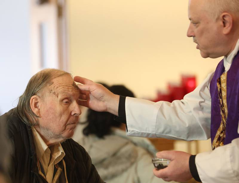 Dennis Czerny of La Salle, receives ashes from Rev. Jeffery Small during Ash Wednesday Mass on Wednesday, Feb. 18, 2026 atThe Queen of the Holy Rosary Memorial Shrine in La Salle. Ash Wednesday marks the beginning of Lent eading up to observances of Jesus' death on Good Friday and resurrection on Easter.