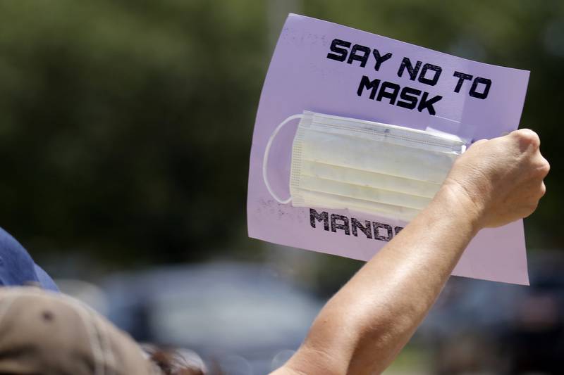 Dozens of demonstrators display their opposition to masks during an Unmask Our Kids rally at the intersection of Rt. 14 and South Main St. on Saturday, Aug. 14, 2021 in Crystal Lake.