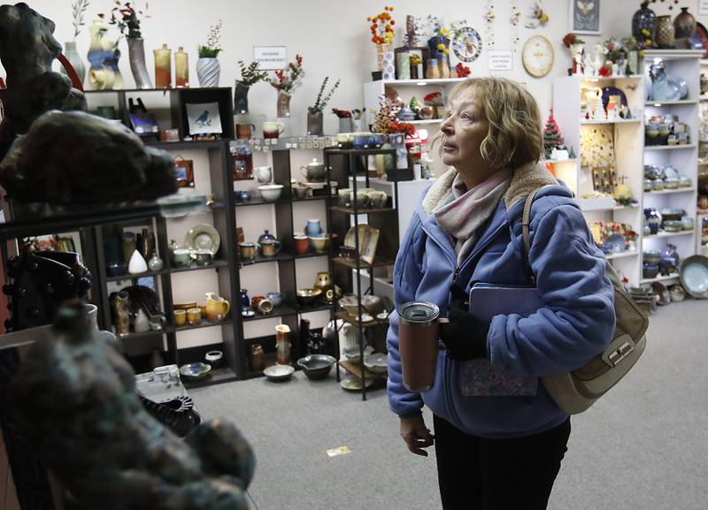 Diane Ray of Woodstock shops on Thursday, Dec. 19, 2024, at Artisans on Main in Woodstock. Several of the artists have holiday themed items for sale.