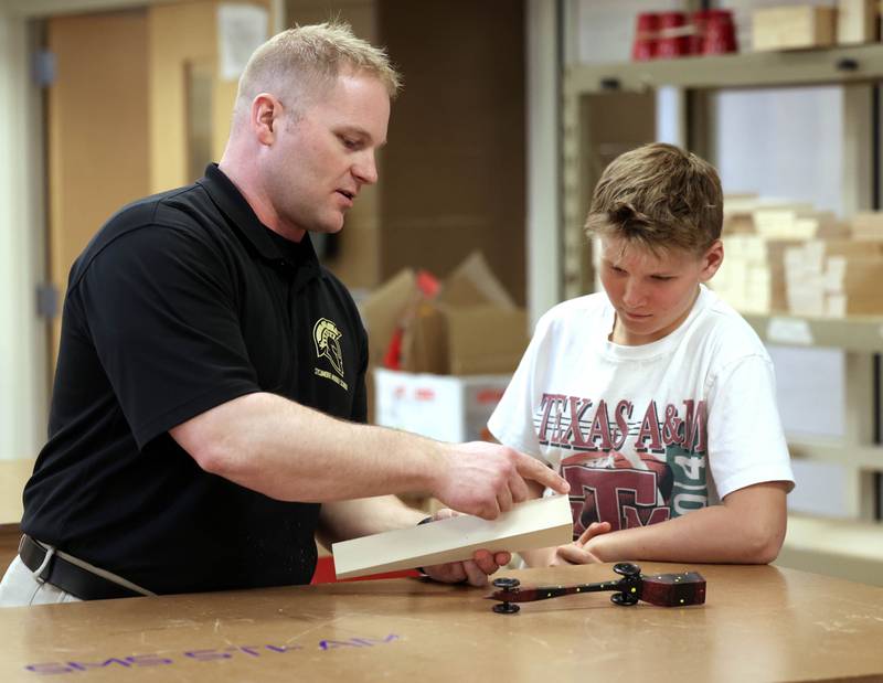 Kevin Boltz, career and technical education teacher at Sycamore Middle School, teaches sixth grader Lincoln Rissman about the CO2 dragsters Friday, April, 11, 2025, in the STEM classroom at the school.