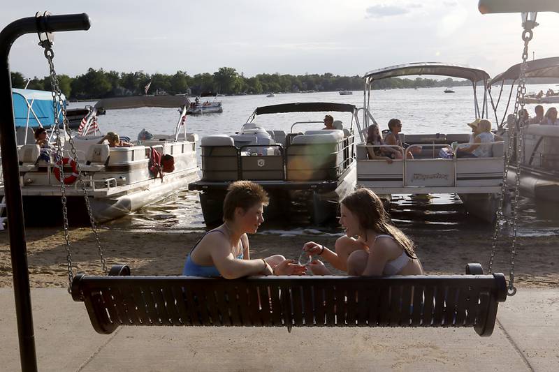Bethany Floyd and Lily Ruley talks as they swing during the Crystal Lake Park District's Concert in the Park on Tuesday, June 17, 2025, at Main Beach in Crystal Lake. The concert was part of the park district's weekly Tuesday night summer concert series.