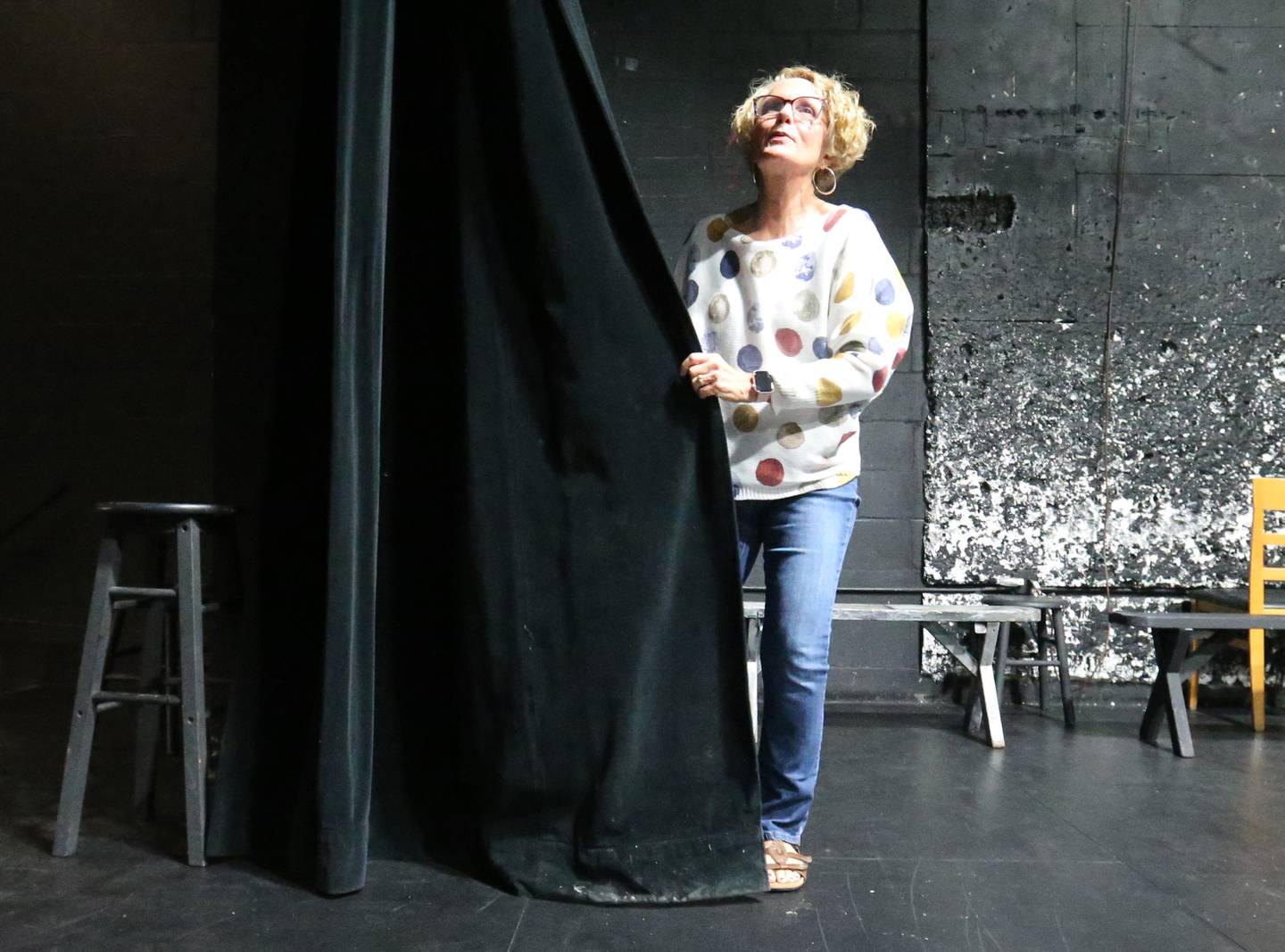Natalie Smigle, fundraising chairwoman, inspects the curtain on Friday, May 2, 2025 at Stage 212 in La Salle. Renovations totaling $162,000 are scheduled to begin this fall. Over $100,000 has been raised from donations so far. The renovations include new seating, curtains, ceiling tiles and acoustic panels.