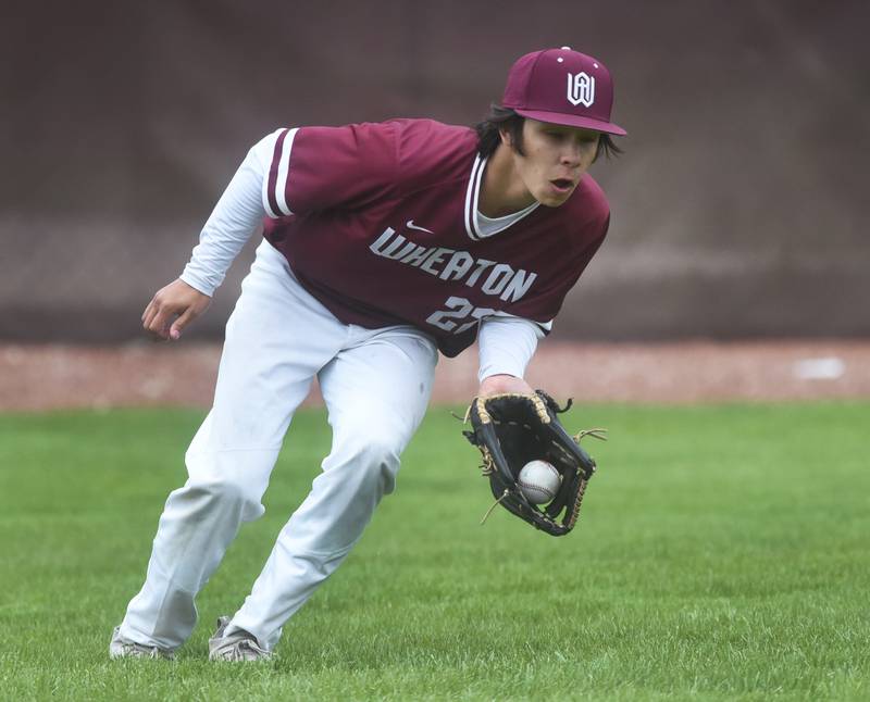 Wheaton Academy's Gino Spinelli scoops up the ball on a St. Francis hit during Tuesday’s baseball game in West Chicago.