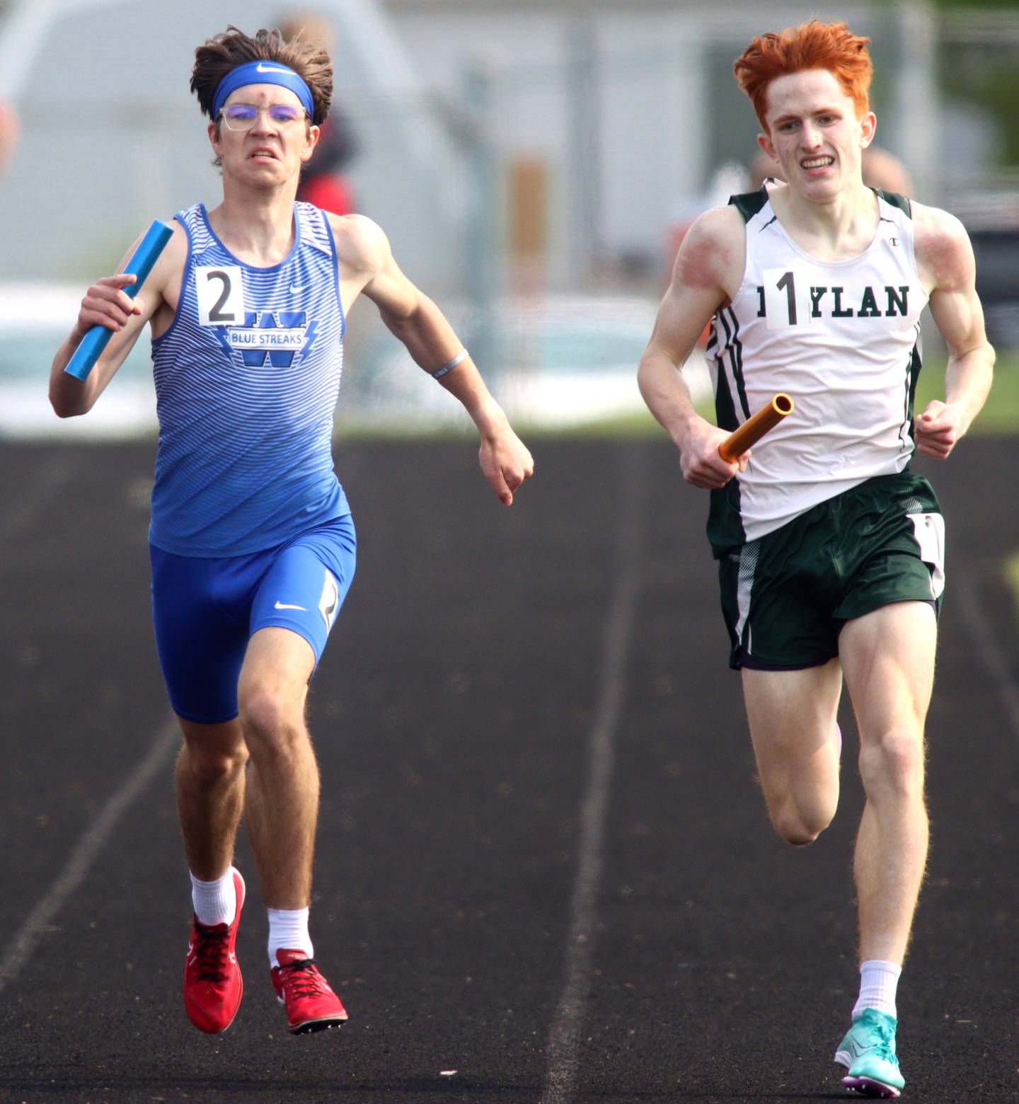 Cohen Shutt, left, of Woodstock, anchors the Blue Streaks’ 3200-meter relay during Class 2A Sectional track at Hugh K. Funderburg Stadium on the campus of Belvidere High School Wednesday, May 17, 2023.