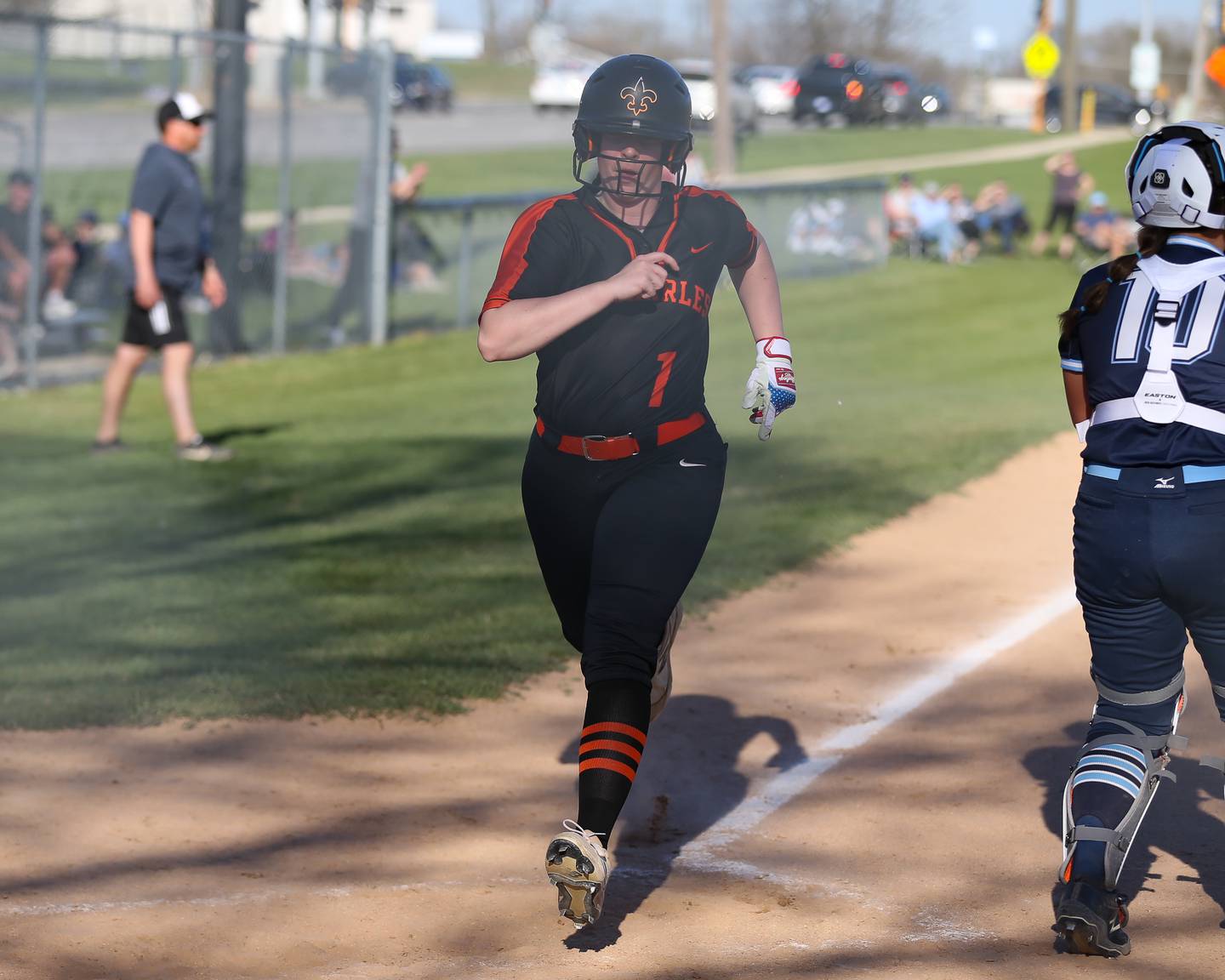 St Charles East's Sam Beers (1) crosses the plate during varsity softball game between St Charles East at Downers Grove South.  April 12, 2023.