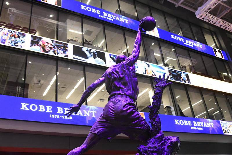 The Michael Jordan statue is illuminated in purple to honor Kobe Bryant before an NBA basketball game between the Chicago Bulls and the San Antonio Spurs Monday, Jan. 27, 2020, in Chicago. (AP Photo/David Banks)