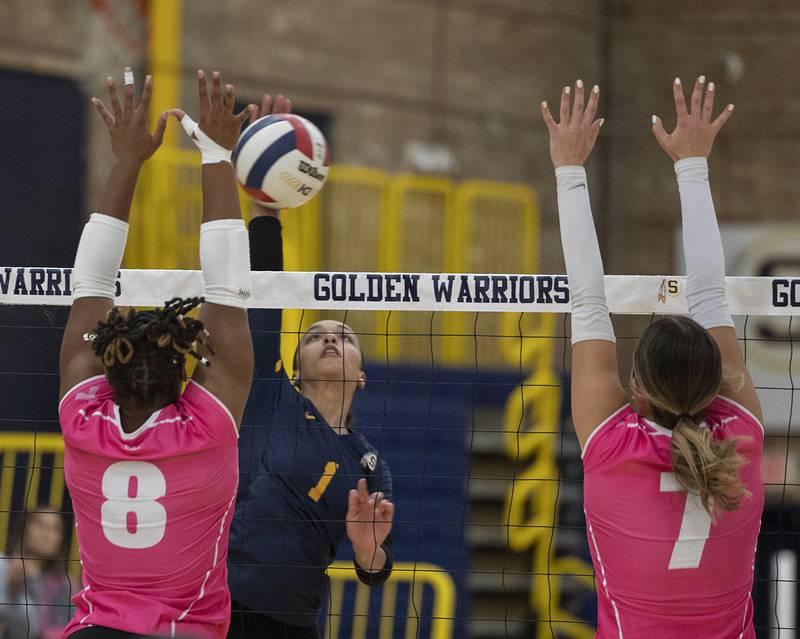 Sterling’s Nia Harris plays the ball over the net against United Township’s Lyric Gordon (left) and Emily Stevens Tuesday, Oct. 15, 2024, in Sterling.