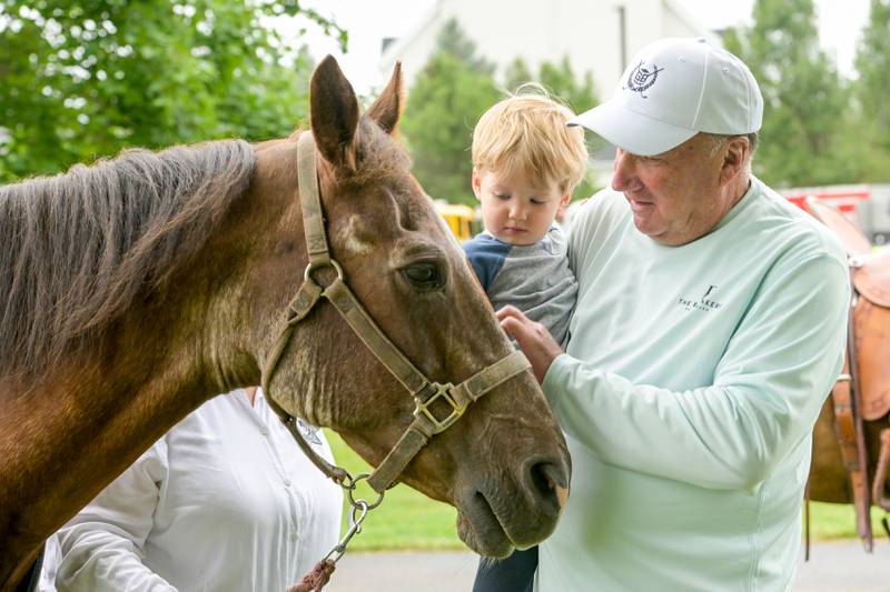 Hudson Wojkowski, 2 and his grandfather Bob Frett pet "Buckaroo" from the Kane County Mounted Rangers during the Campton Hills National Night Out on Tuesday, August 6, 2024.