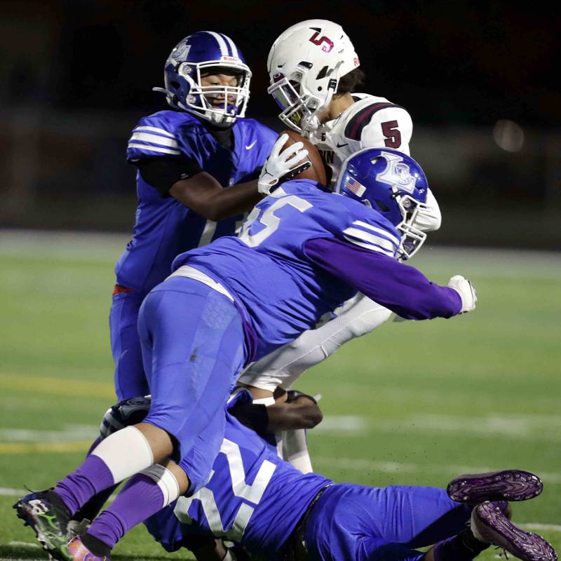 Elgin's Dawayne Evans (5) is brought down by a host of Larkin players including Kevin Malone (22)  Robert Grant (55) and Jorge Ambris (13) during the annual crosstown rival game at Memorial Field  Friday October 14, 2022 in Elgin.