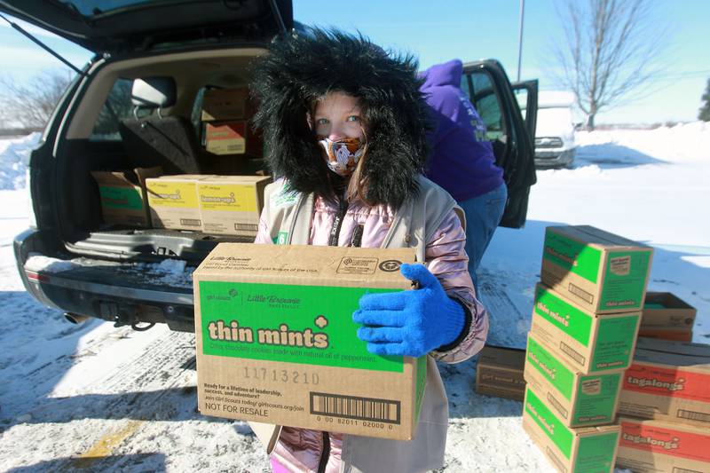 Ryley Keith, 11, of Wonder Lake carries a box of thin mints as she helps sort boxes of Girl Scout Cookies for her Girl Scout Cadette Troop #41680 at the Big Hollow Middle School parking lot in Ingleside.  (2/7/21)