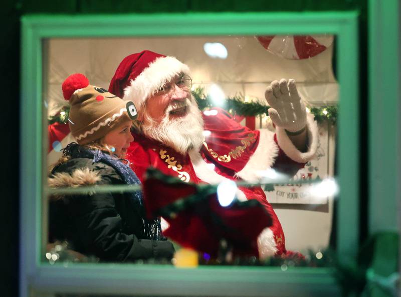 Santa Claus and Coraline Reed, 5, from DeKalb, visit Thursday, Dec. 5, 2024, in his house near the Egyptian Theatre during the DeKalb Chamber of Commerce’s Lights on Lincoln and Santa Comes to Town.