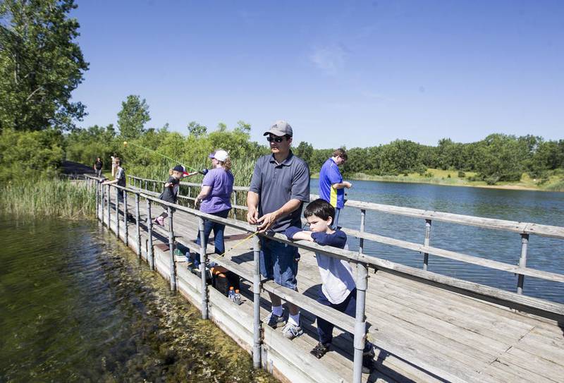 Matt Martin (left) of Crystal Lake and his son, Patrick Martin, 6, fish off the dock while attending Hooked on Fishing hosted by the McHenry County Conservation District at the Hollows Conservation Area in Cary Sunday, June 19, 2016. The event introduced families to fishing with demonstrations, prizes and more,