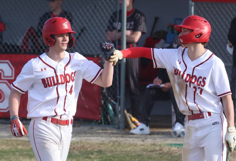 Streator's Clay Cristoff hi-fives teammate Brennen Stillwell after scoring a run on Thursday, March 19, 2026 at Streator High School.