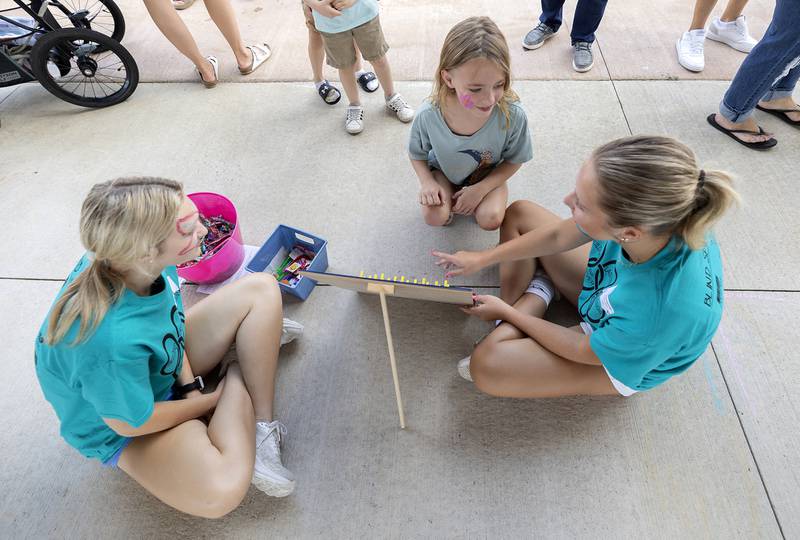 Chevella McPherson, 7, plays a game lead by Building Lasting Impressions that Never Die (BLIND) leaders Allie Russell (left) of Prophetstown and Macie Rosengren of Newman on Friday, Aug. 2, 2024, during Sterling’s Hot Dog Day.