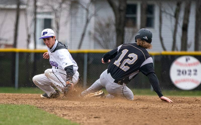 Sycamore's Griffin Hallahan (12) slides under the tag by Plano’s Christian Sloat (14) during a baseball game at Plano High School on Monday, April 4, 2022.