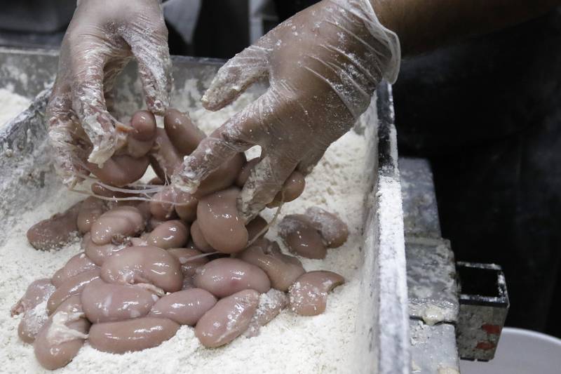 Parkside Pub cook Alfredo Andrado prepares a handful of turkey testicles to be coated in flour prior to deep frying with head cook Javy Garcia during the 39th annual Turkey Testicle Festival at Parkside Pub on Wednesday, Nov. 24, 2021, in Huntley.