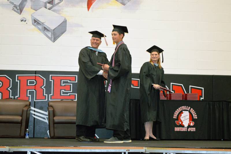 Forreston High School senior Alexander Milnes accepts his diploma from Forrestville Valley School District Board of Education member Chip Braker during the Class of 2023's commencement on May 14, 2023. To the right is district Superintendent Sheri Smith. Milnes plans to study mechanical engineering at Highland Community College.